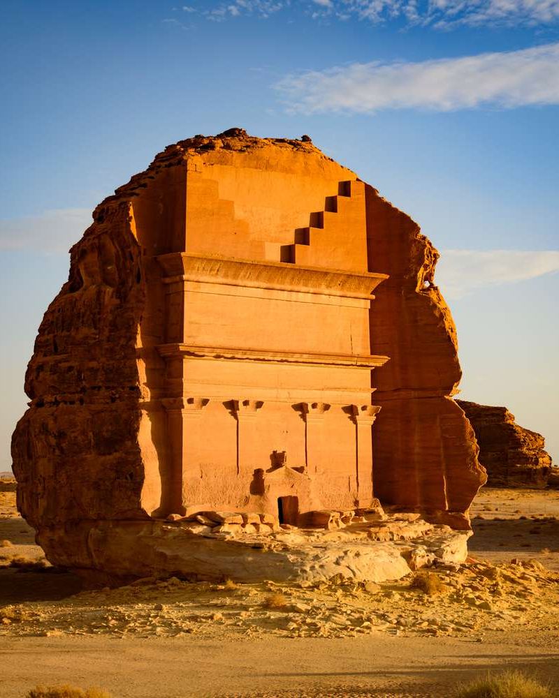 The carved tomb facade of Hegra glowing in early light